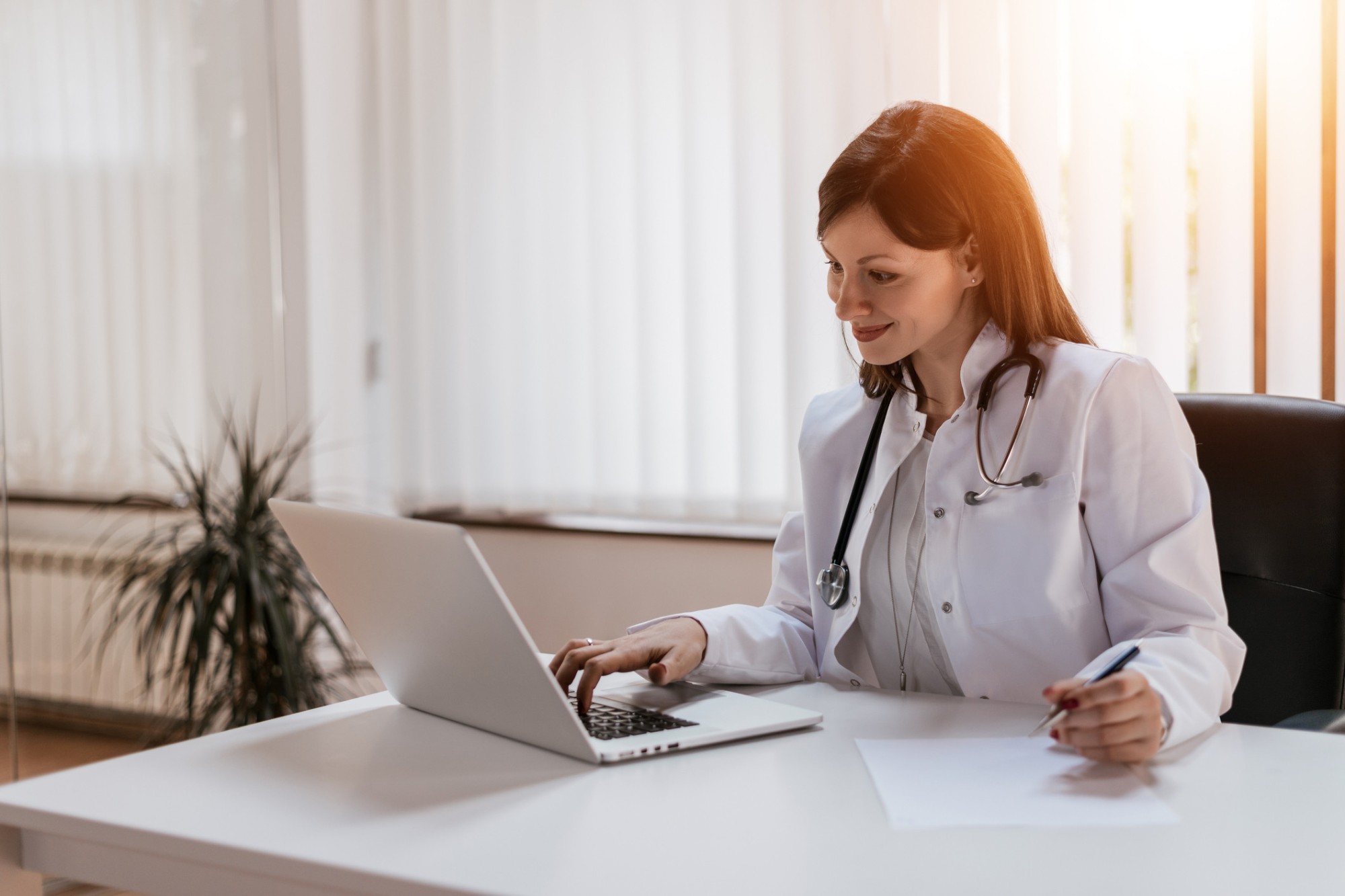 Médica olhando no computador um site para clínicas
