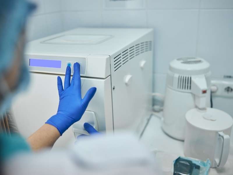 Médica utilizando maqui de esterilização.