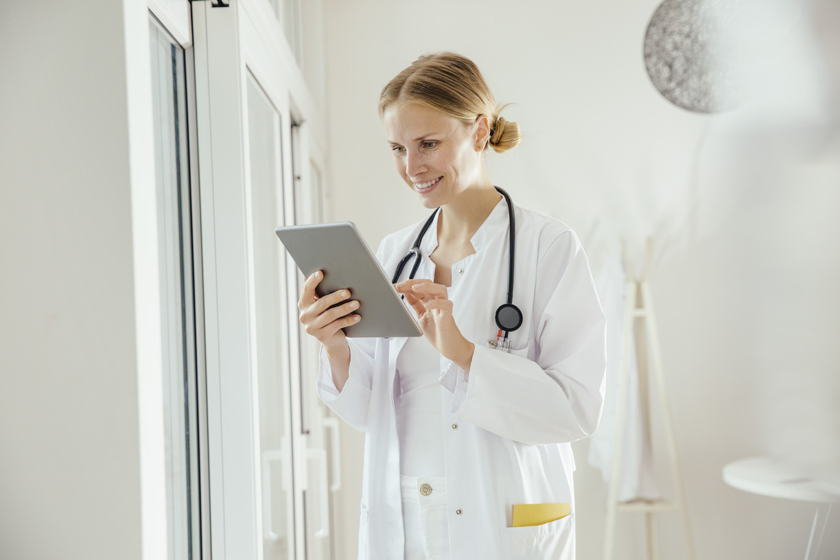 Médica sorridente usando tablet digital