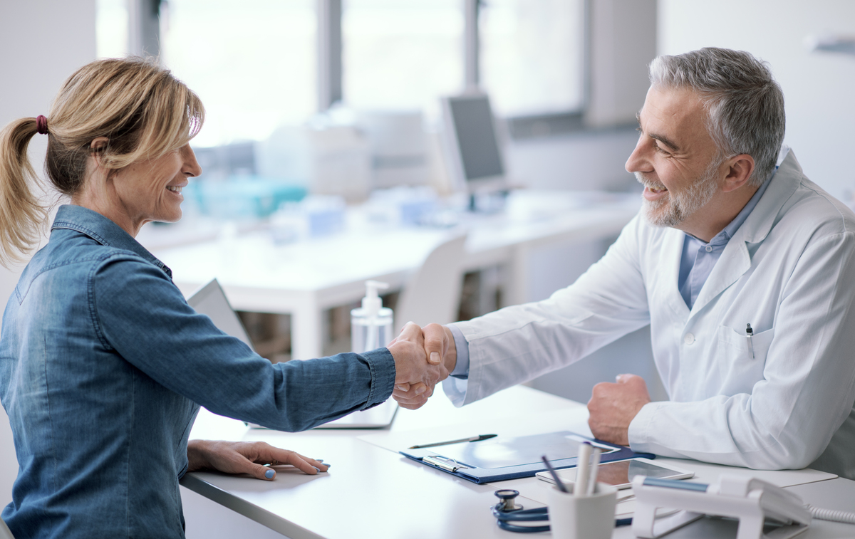 Médico e paciente apertando as mãos
