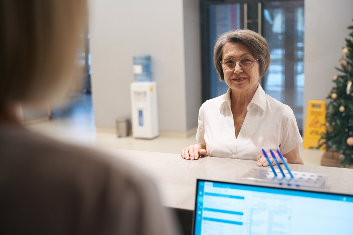 Mulher idosa está na recepção da clínica